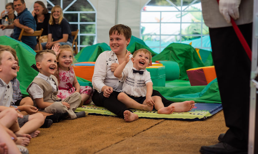 Children happily watching an entertainer during a christening