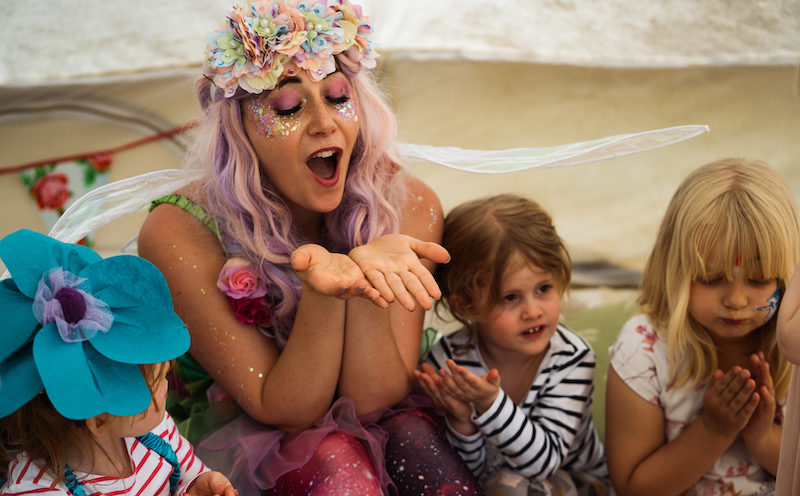An entertainer runs an activity with children at a party