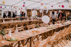 A rustic setup at a vintage-themed wedding with guests standing in the background